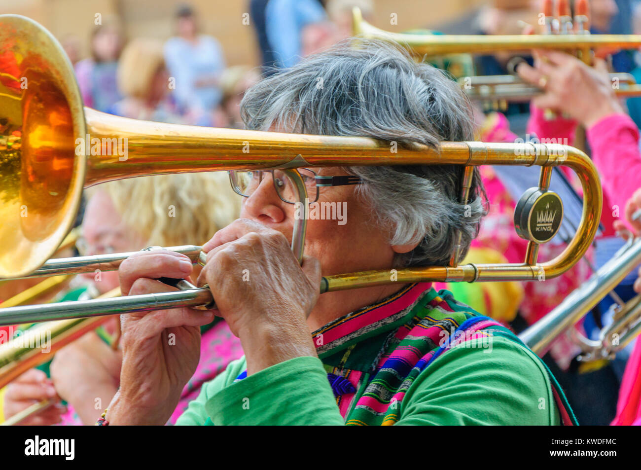 Female musician wearing glasses and playing a trombone in the Carnival