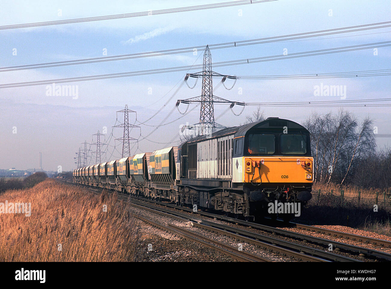 A class 58 diesel locomotive number 58026 with a train of Bardon stone wagons approaches Hoo Junction in Kent. 11th March 1995. Stock Photo