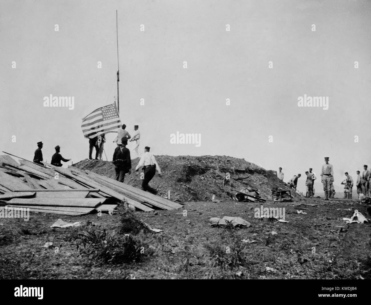 Hoisting the flag at Guantanamo, June 12, 1898 during the Battle of Camp McCalla. The Marines invaded on June 6th, and supported by 3 ships of the US Navy, withstood the resistance of Spanish troops, with six Marines killed in action (BSLOC 2017 10 20) Stock Photo