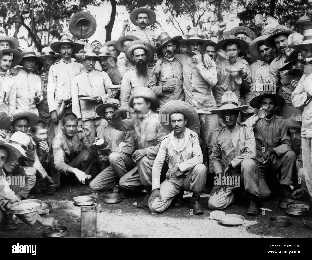 Spanish prisoners of war eating in US captivity in Manila, 1898. The Philippine revolutionary soldiers led by Emilio Aguinaldo turned over 15,000 Spanish POWs to the Americans in May-June 1898. Filipinos fought in the countryside as informal US allies against the Spanish, while the Deweys fleet awaited the arrival of US Expeditionary force (BSLOC 2017 10 67) Stock Photo