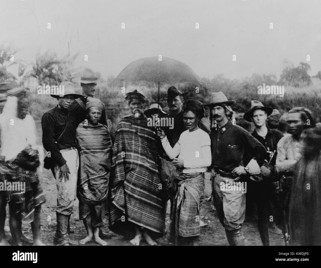 Captain John Pershing standing behind the Rajamunda of Marahai and his slave, holding an umbrella over the Rajamunda. Photo was taken during Pershings trip along Lake Lanao with he Capt. James Ryan (2nd from right), his successor. Nov. 30, 1902. At far left is Pershings interpreter, Leon Fernandez (BSLOC 2017 10 97) Stock Photo