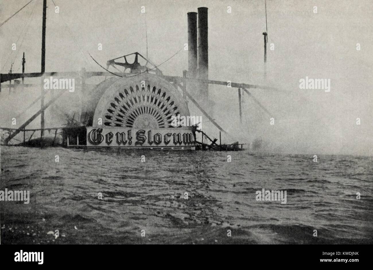 Smoking wreck of the GENERAL SLOCUM showing the housing of the paddle wheel, June 15, 1904. 1,021, mostly women and children, were killed by the excursion boat fire or drowning (BSLOC 2017 17 111) Stock Photo