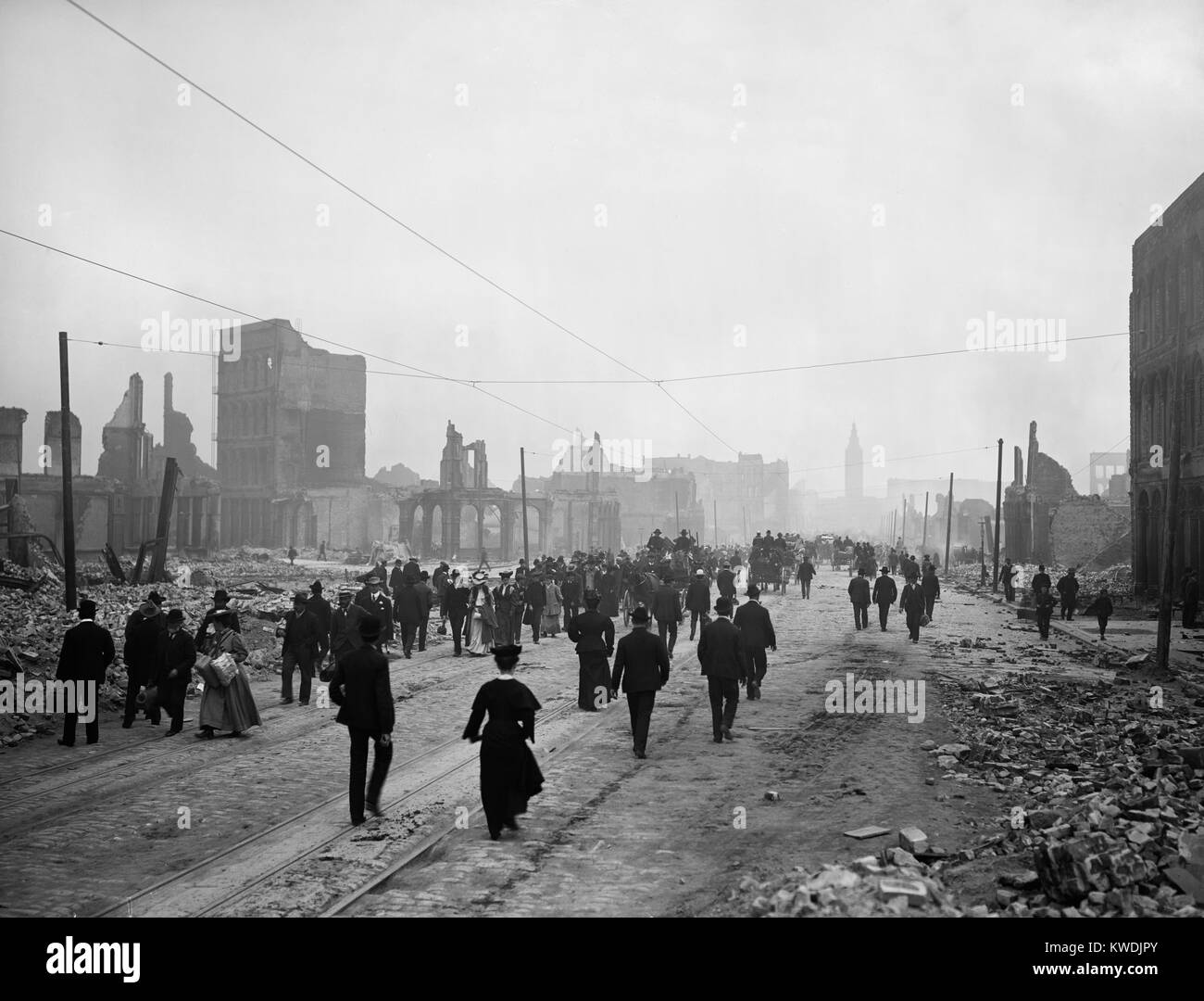 People walk on Market St. toward the ferry to leave San Francisco after the April 1906 earthquake. Of the citys 440,000 approximately 250,000 evacuated the city shortly after the disaster (BSLOC 2017 17 31) Stock Photo