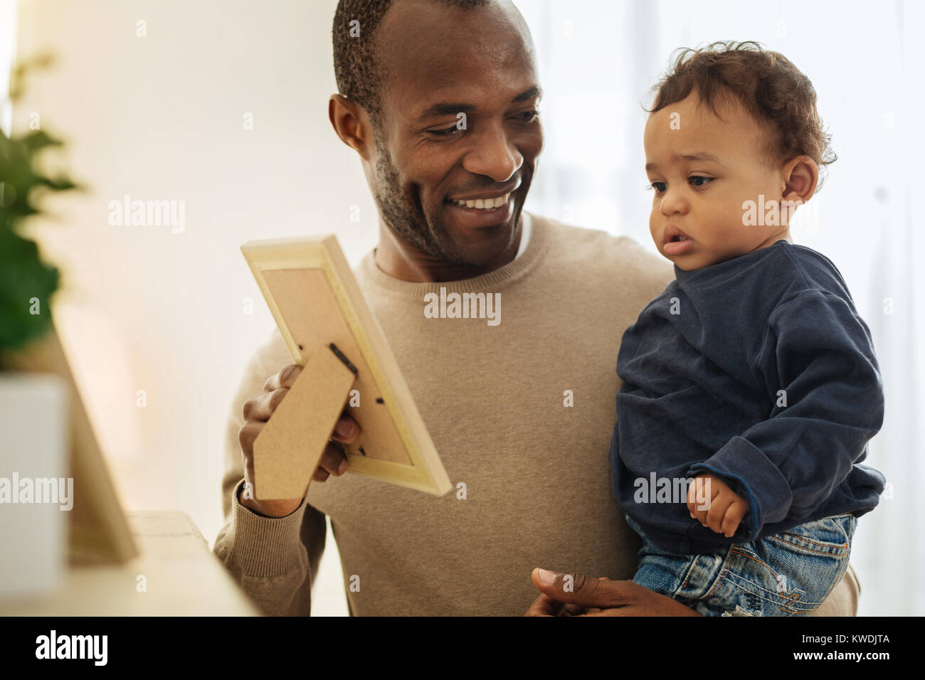 Cheerful daddy showing photos to his son Stock Photo