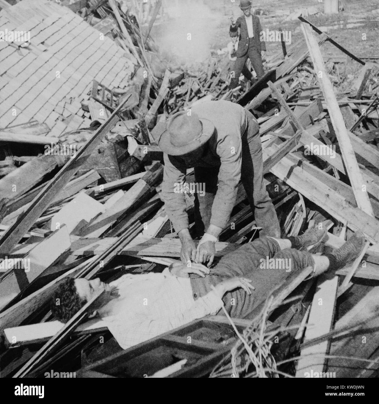 Photo shows a man who has discharged a pistol aimed at a looter in Galveston, Texas, Sept. 1900. The photo is likely set up, shows a thief removing a ring from the hand of a dead victim of the Great Galveston Hurricane (BSLOC 2017 17 87) Stock Photo