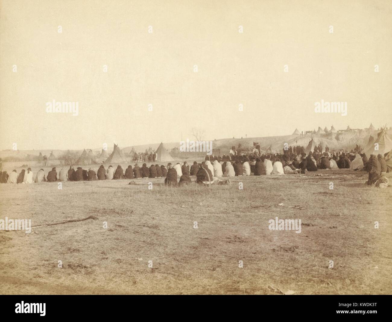 Native Americans in council after Wounded Knee Massacre of Dec. 29, 1890. Rear view of a large semi-circle of Lakota men sitting on the ground, with tipis in background, on Pine Ridge Reservation during re-establishment of peace in Jan. 1891. Photo by John Grabill, Jan. 1891 (BSLOC 2017 18 28) Stock Photo