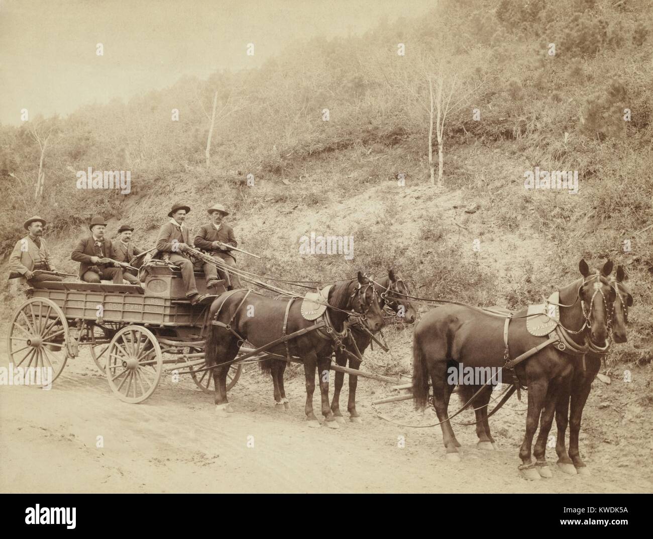 A Wells Fargo Express Wagon and Guards carry $250,000 gold bullion in South Dakota, 1890. Four men, holding rifles guard the shipment from the Great Homestake Mine of Deadwood, SD (BSLOC 2017 18 56) Stock Photo