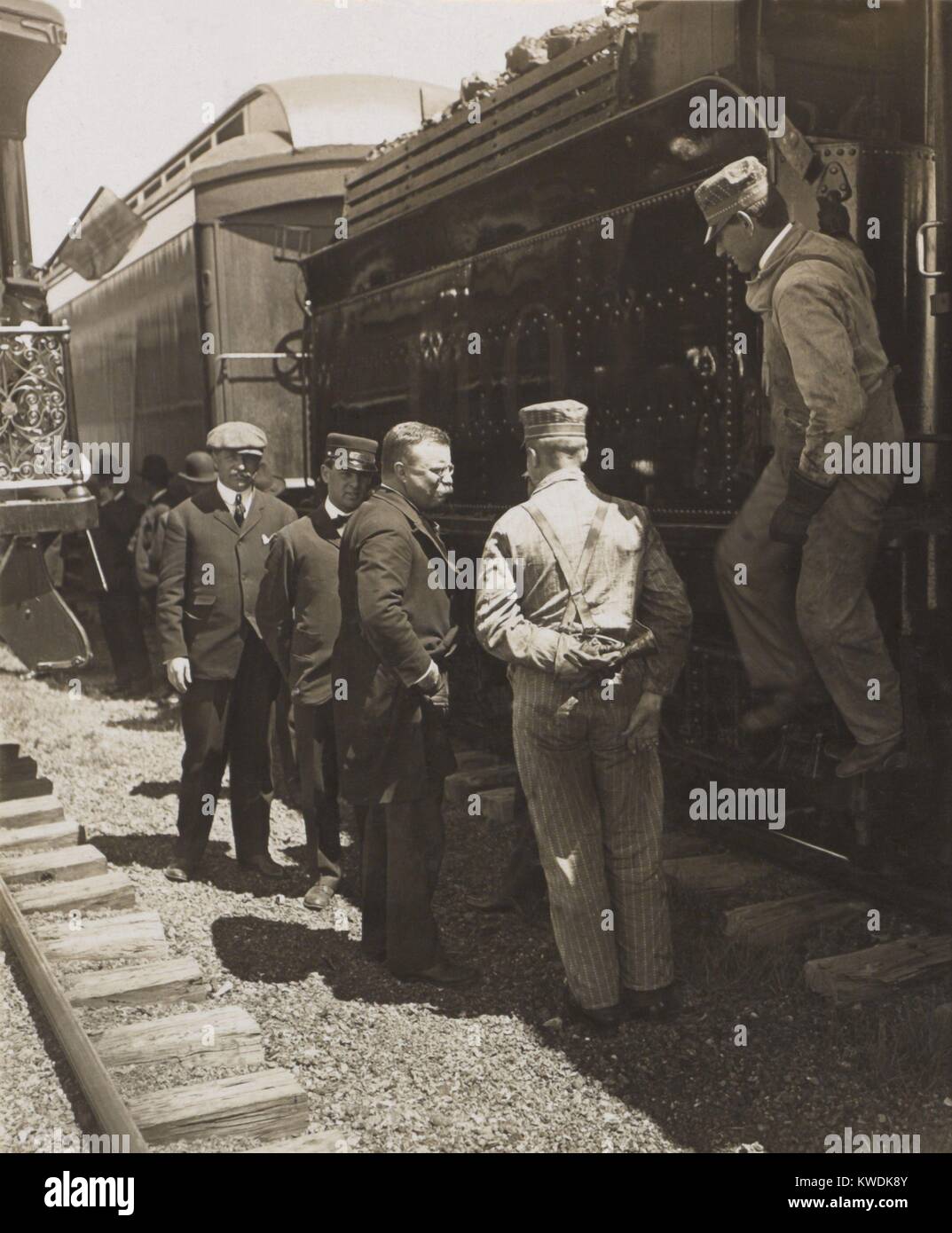 President Theodore Roosevelt talking with railroad workers, April-June 1906. Standing beside the coal car, the group includes locomotive operators and conductors. Unidentified location (BSLOC_2017_6_62) Stock Photo