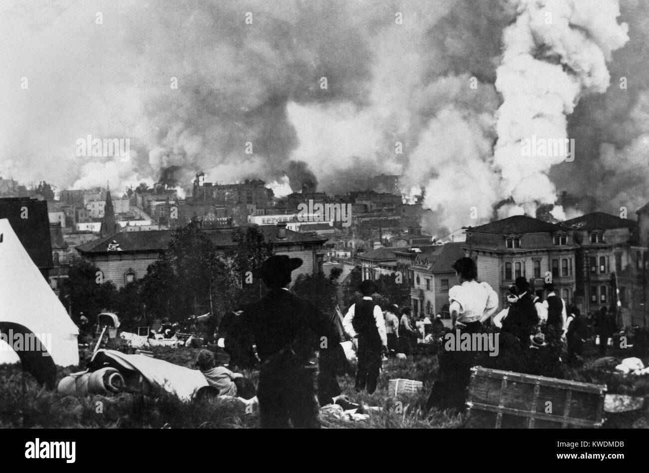 San Francisco burning after April 18, 1906 earthquake viewed by people in Golden Gate Park. Note the trunks and bundles of peoples belongings of now homeless San Franciscans (BSLOC 2017 17 17) Stock Photo