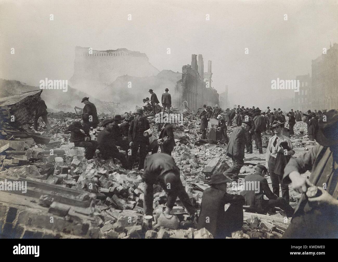 Scavengers in the rubble after the April 18, 1906 San Francisco Earthquake and 3-day fire. A few men appear to be opening tin cans, probably of food found in the ruins (BSLOC 2017 17 30) Stock Photo