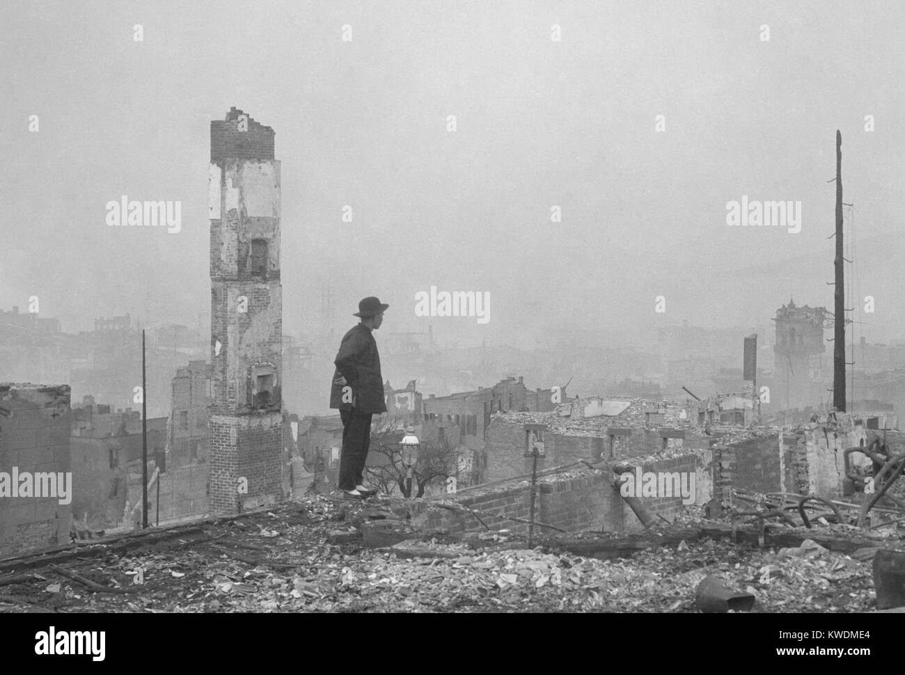 A Chinese man stands in the ruins of San Franciscos Chinatown after the April 18, 1906 earthquake. Of the 15,000 Chinese living in San Francisco’s Chinatown most Chinese left for Oakland, with only 400 remaining in the city. The post-earthquake Committee on the Location of Chinatown allowed the re-building so not to lose tax revenues and Oriental trade (BSLOC 2017 17 34) Stock Photo