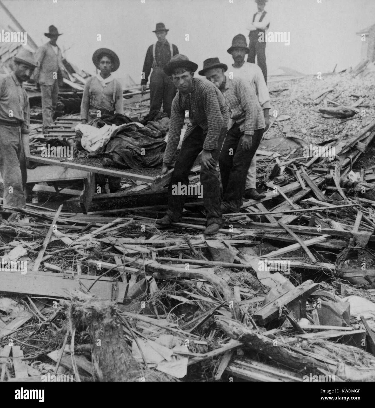 Men carrying bodies on stretcher, surrounded by wreckage of the hurricane in Galveston, Texas, Sept. 1900. The disaster occurred on Sept. 8th, but relief efforts took two days to get underway and took weeks (BSLOC 2017 17 85) Stock Photo