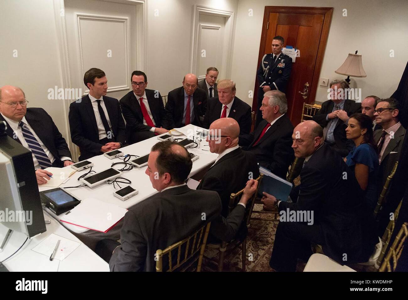 President Donald Trump and the National Security Council are briefed on a military strike on Syria. On April 8, 2017, the briefing included a video teleconference with Defense Secretary Gen. James Mattis, and Gen. Joseph F. Dunford. The Presidents son-in-law, Jared Kushner is 2nd from left. Steve Bannon, the Presidents chief strategist, sits by the lamp (BSLOC 2017 19 14) Stock Photo