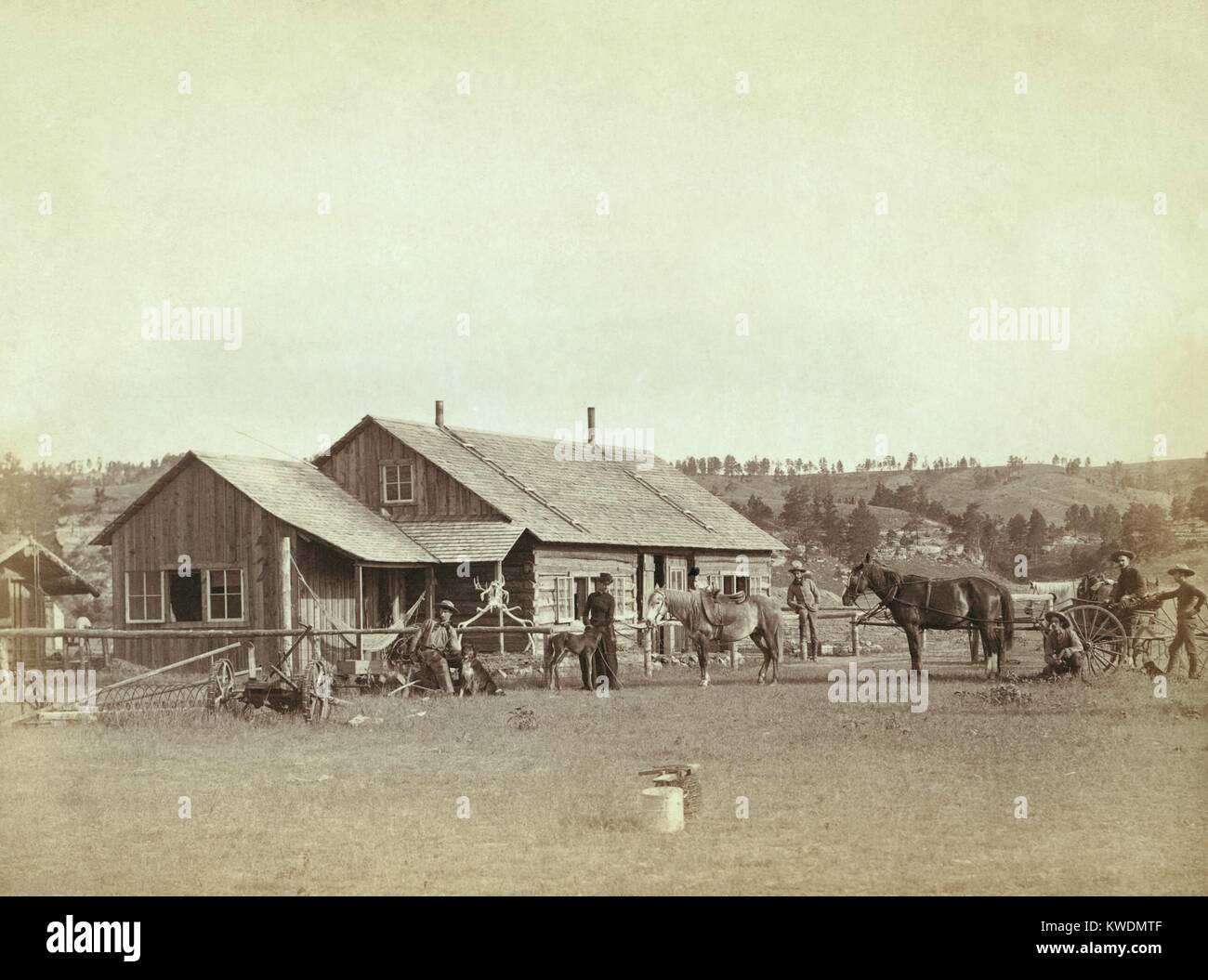 Men and a woman in front of a western ranch house, in South Dakota, 1887. As the Euro-American population reached 500,000 in 1885, compared to 70,000 Native Americans, the pressure for the reorganization and reduction of the Great Sioux reservations could not be resisted in Washington (BSLOC 2017 18 58) Stock Photo