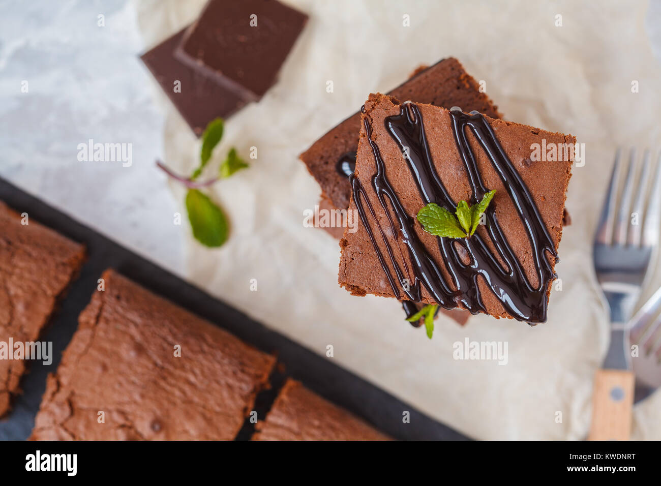 Pieces of healthy vegan pumpkin chocolate brownie with chocolate (carob) syrup on slate board Stock Photo