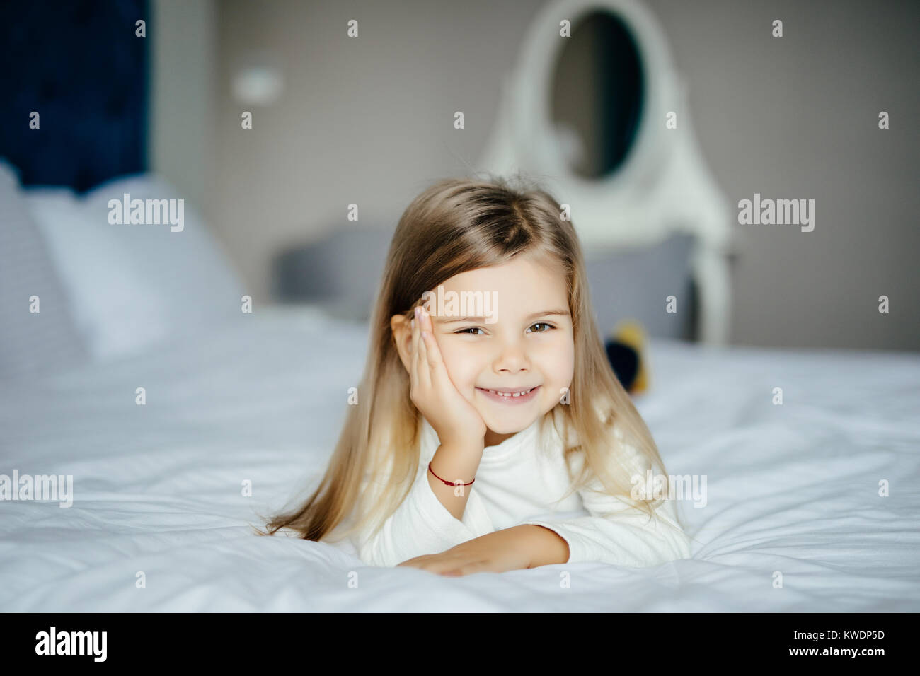 Cute little girl lying in bed at home Stock Photo - Alamy
