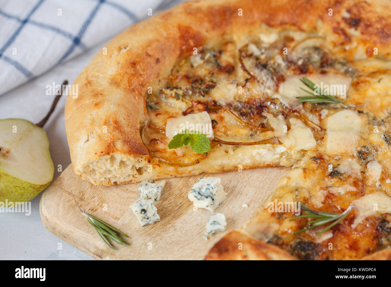Hot delicous pizza with pear and blue cheese on wooden board. Vegetarian healthy food concept, traditional Italian food. Stock Photo