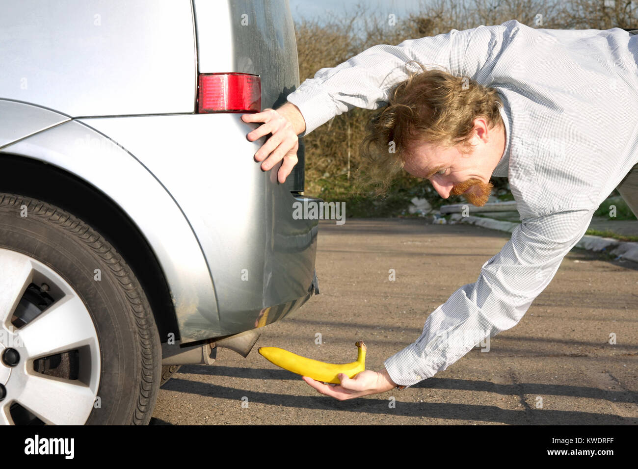 Man putting banana into car exhaust pipe Stock Photo Alamy