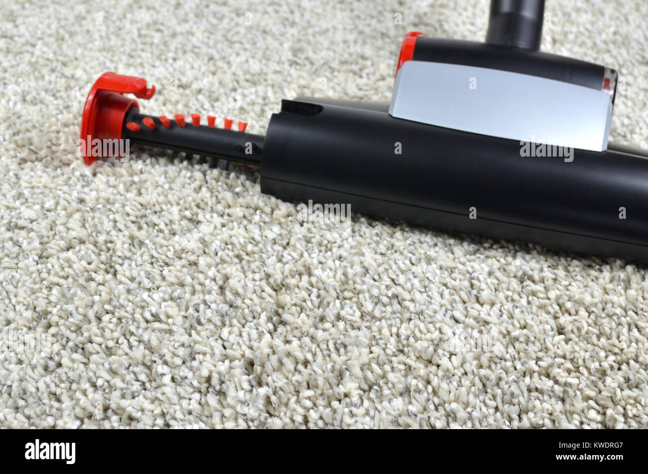 Pet hairs vacuum cleaner brush on grey shaggy carpet surface Stock