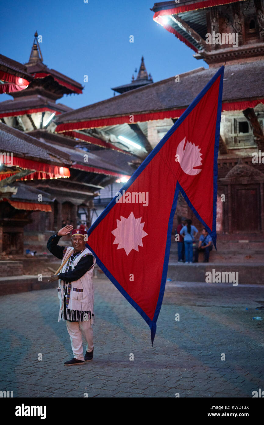 Nepali man with Nepali flag posing for local tourists, Durbar Square, Katmandu Stock Photo