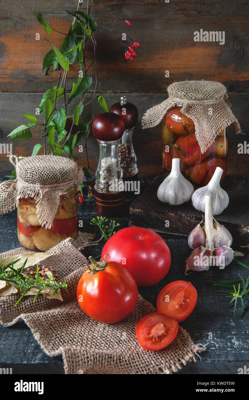 Homemade canned tomatoes in glass jars in a rustic style. The concept