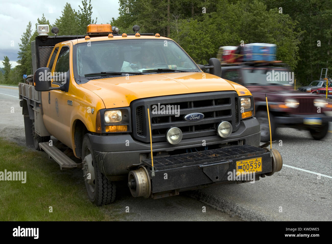 Special prepared yellow, hi-rail truck for moving and working on railway tracks, parked on the side of one of the main roads in Alaska Stock Photo