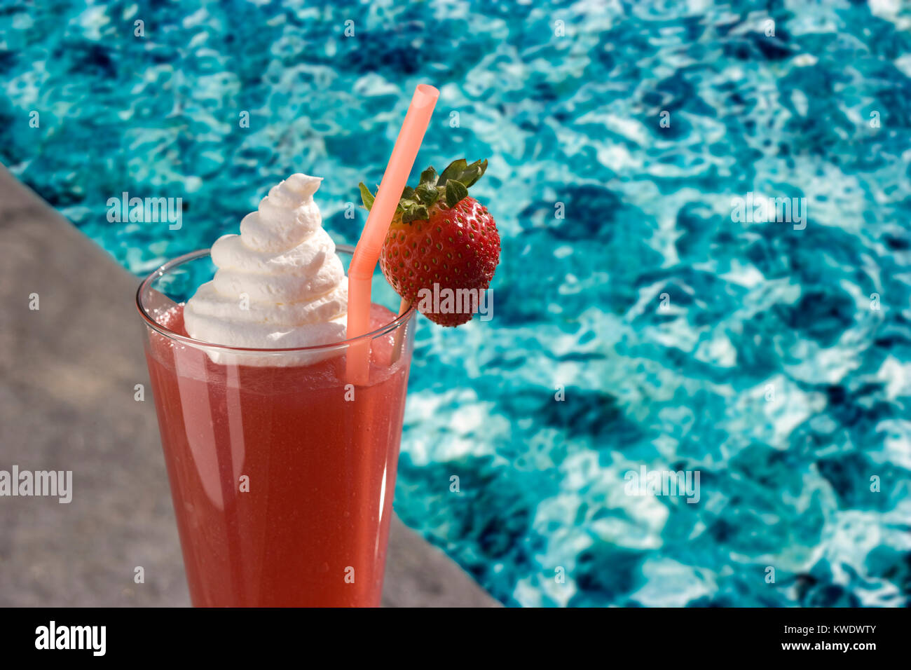 Frozen Strawberry Daiquiri with Garnishes next to Swimming Pool Stock