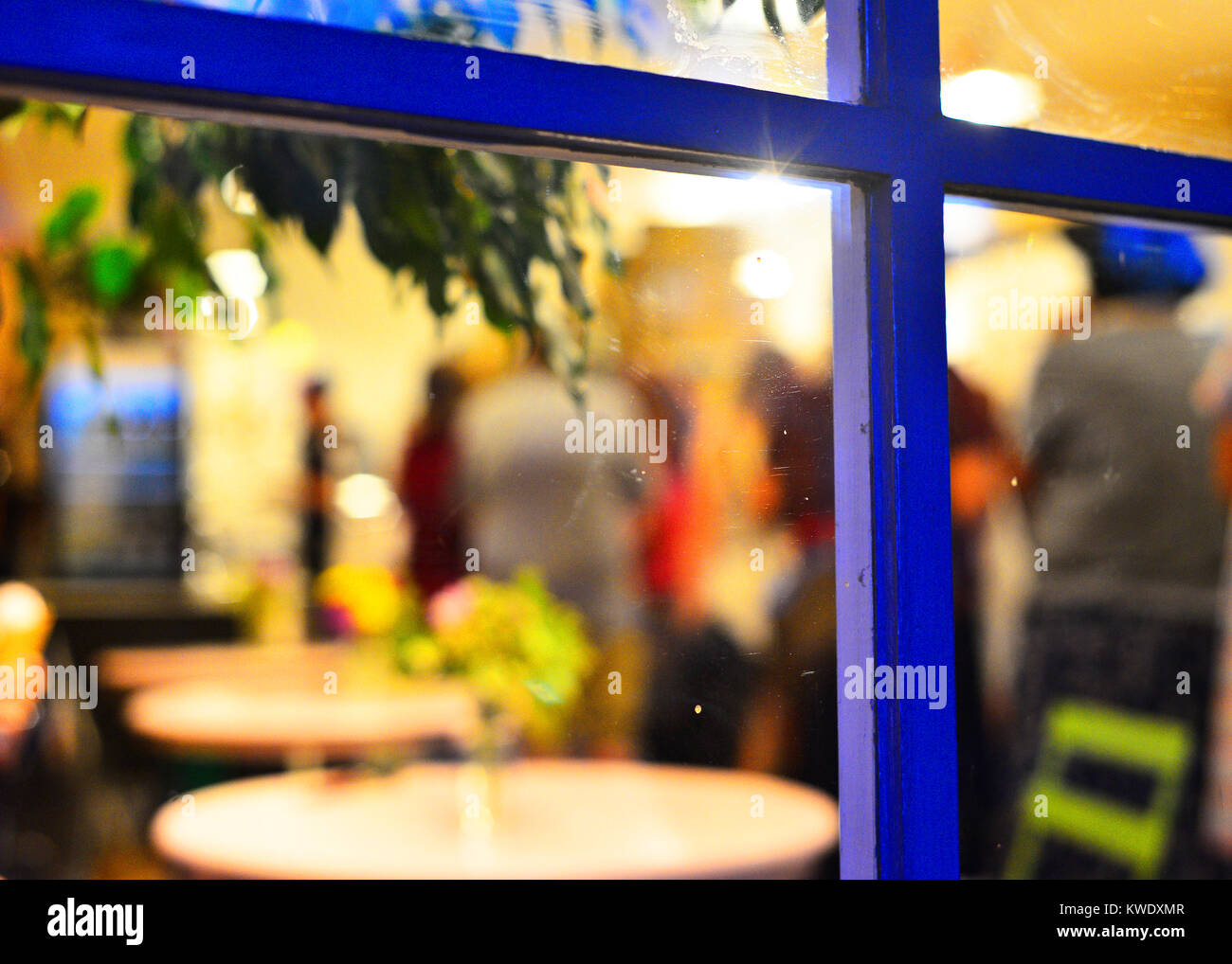 People waiting in line at a cafe through the window. Stock Photo