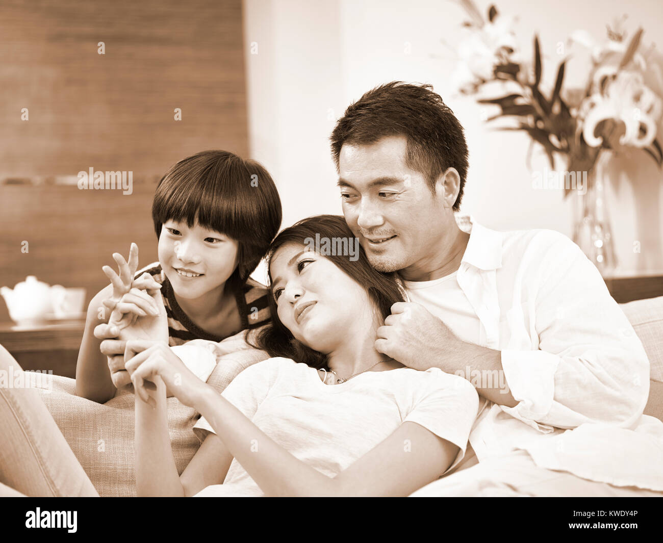 asian parents with one child enjoying time together at home, black and white sepia. Stock Photo