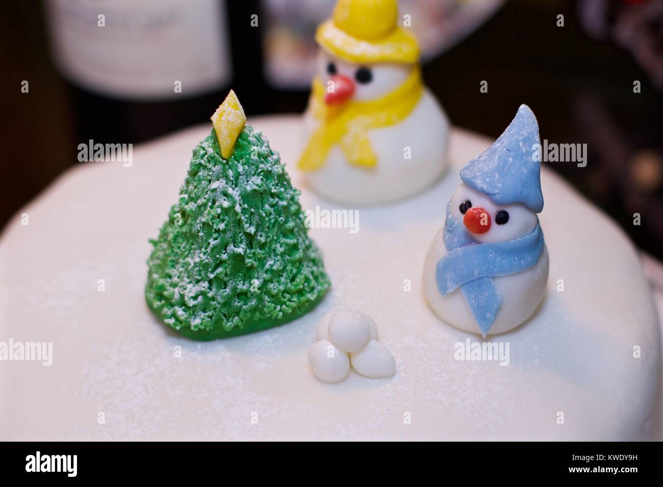 Penguins and Christmas tree made of icing sugar on top of Christmas cake Stock Photo