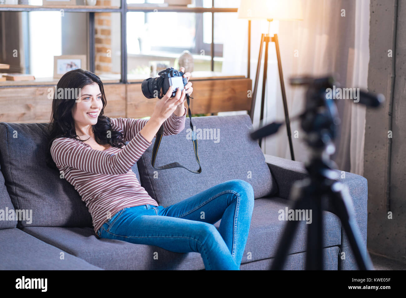 Cheerful happy woman sitting on the sofa Stock Photo