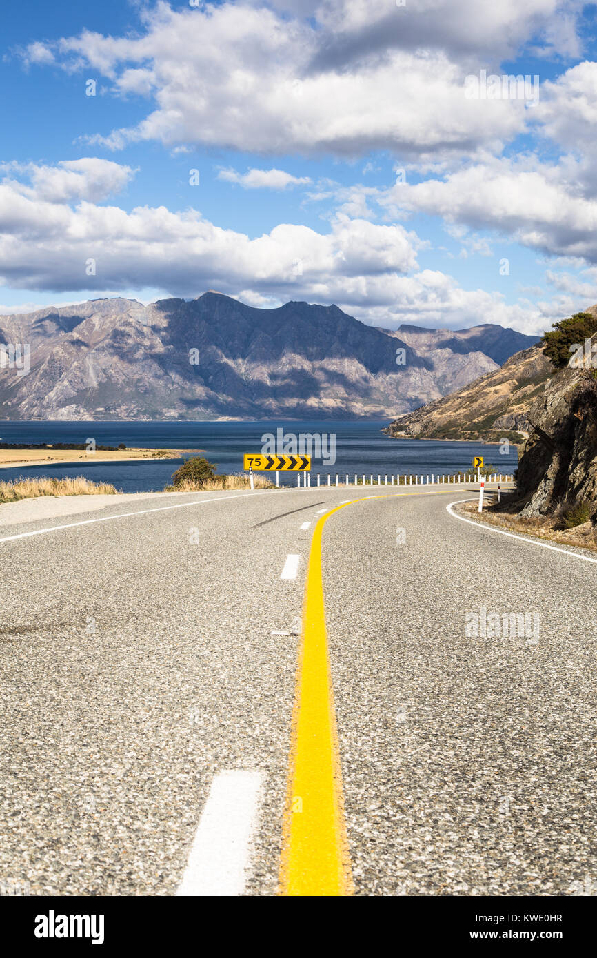 On the road between lake Hawea, in the background, and lake Wanaka near the tourism town of Wanaka in Canterbury district of New Zealand south island. Stock Photo