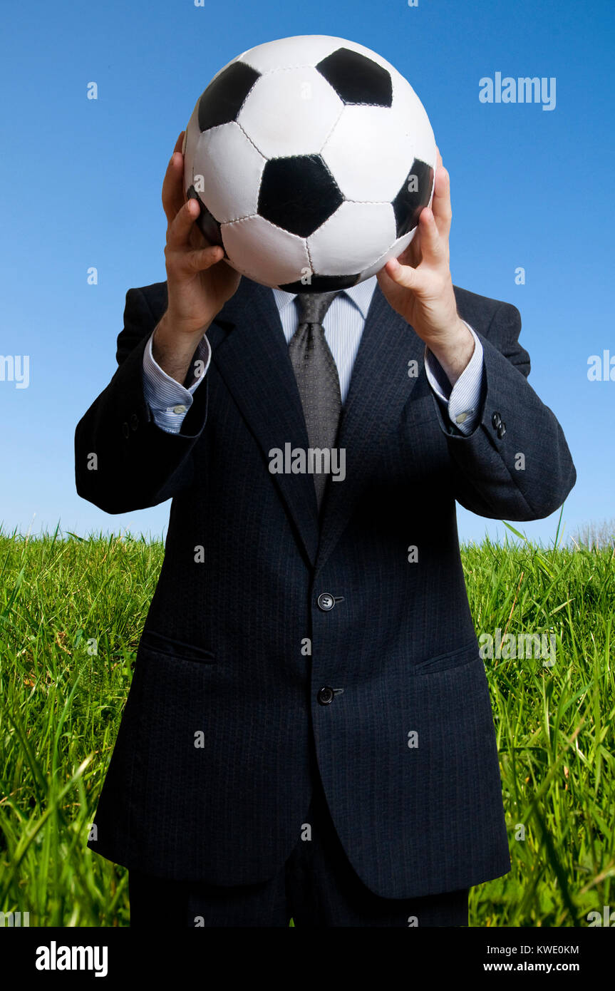 man in suit holding a soccer ball in front of his face, sport as ...