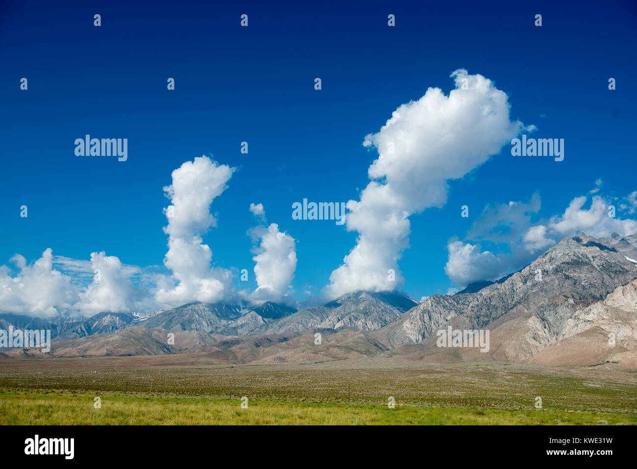Scenic view of mountain ranges at Owens Valley against cloudy sky Stock Photo