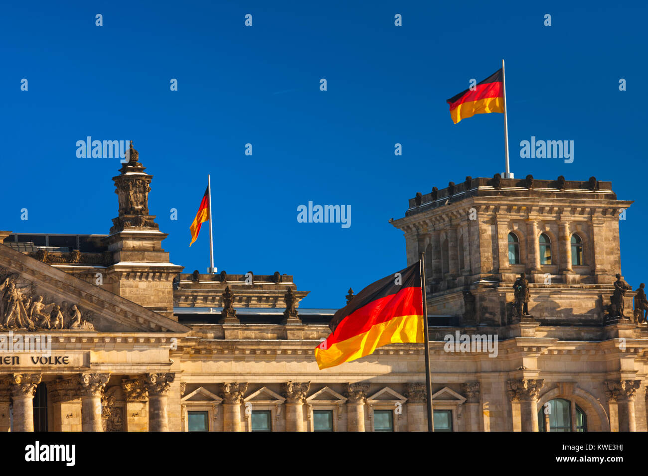 The Reichstag building in Berlin with german flags and deep blue sky. Stock Photo