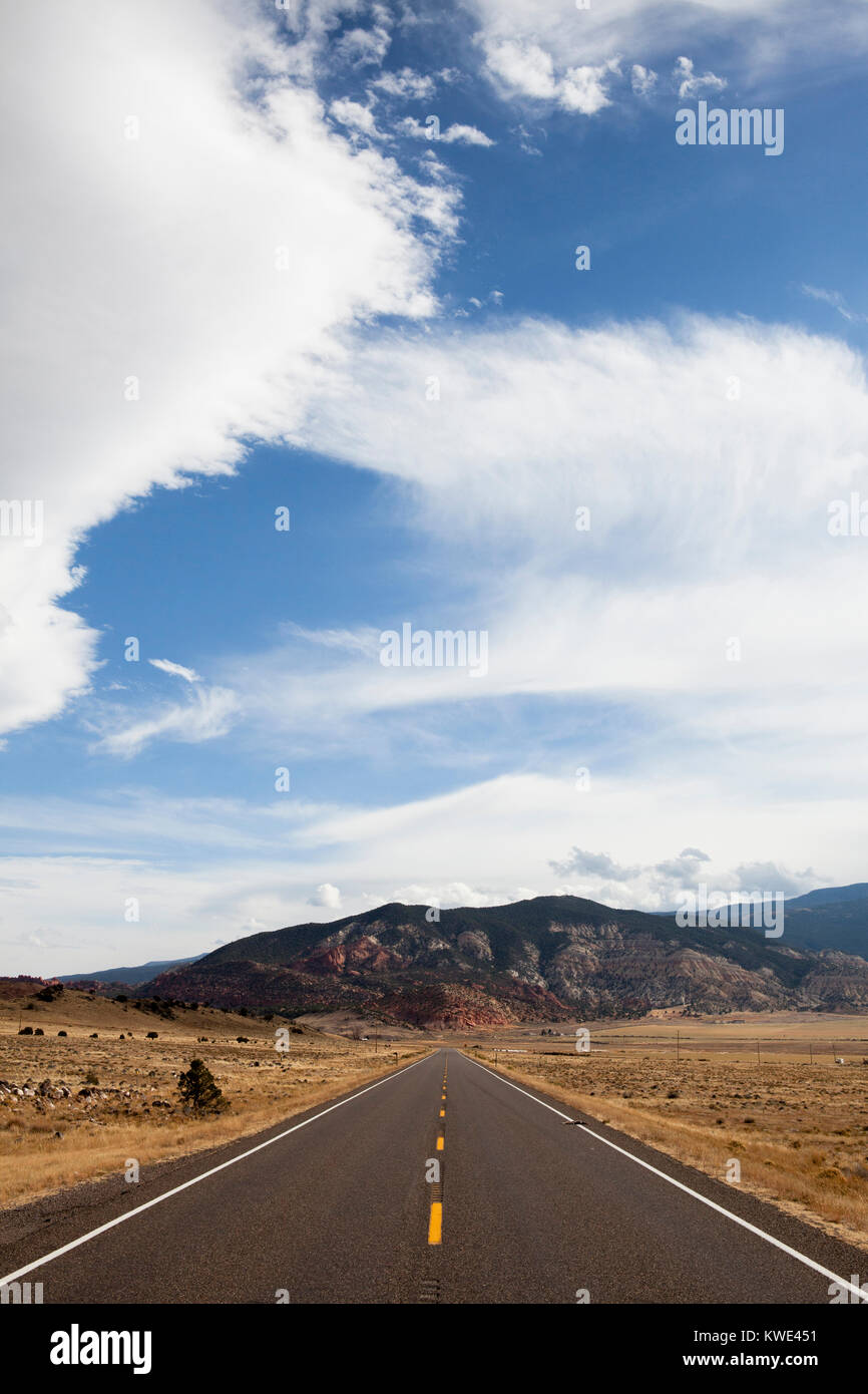 Country road against mountains and cloudy sky Stock Photo