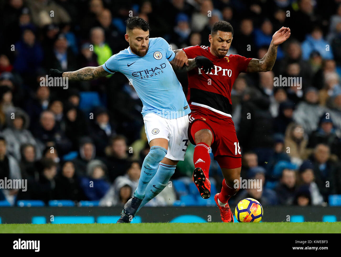 Manchester City's Nicolas Otamendi (left) and Watford's Andre Gray (right) battle for the ball during the Premier League match at the Etihad Stadium, Manchester. Stock Photo