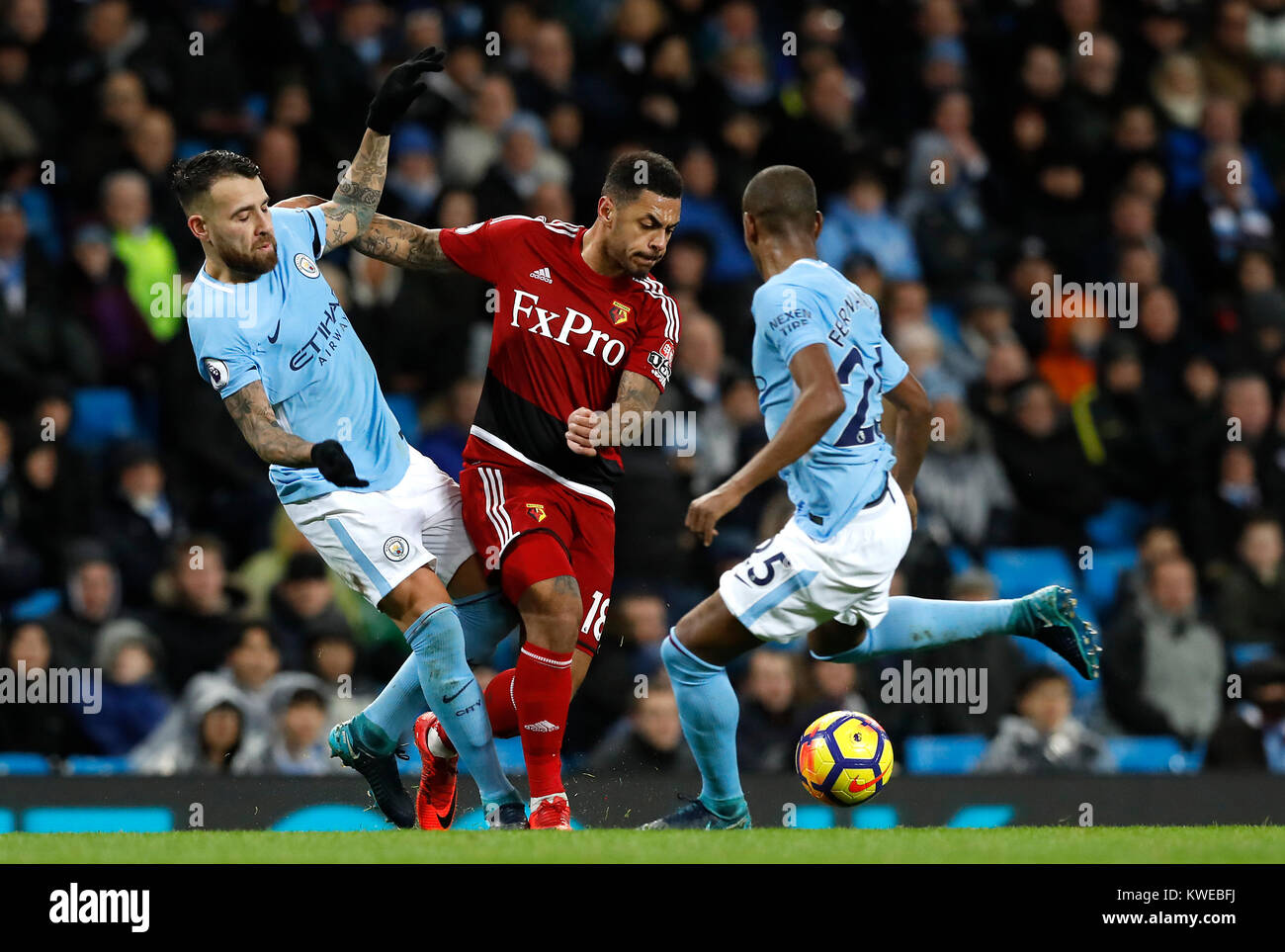 Manchester City's Nicolas Otamendi (left) and Luis Fernandinho (right) battle for the ball with Watford's Andre Gray (centre) during the Premier League match at the Etihad Stadium, Manchester. Stock Photo