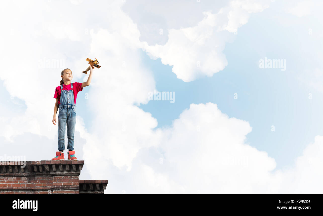 Concept of careless happy childhood with girl dreaming to become pilot Stock Photo