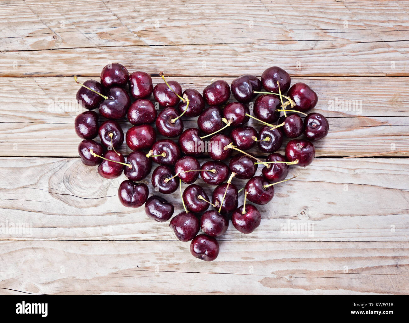 Large Heart of fresh and ripe cherry on wooden background Health care concept Valentine's day Stock Photo