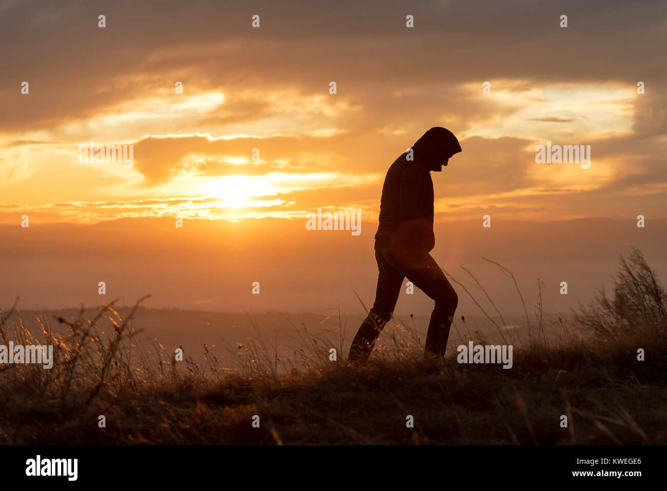 silhouette of man standing on the top of mountain at sunset Stock Photo ...