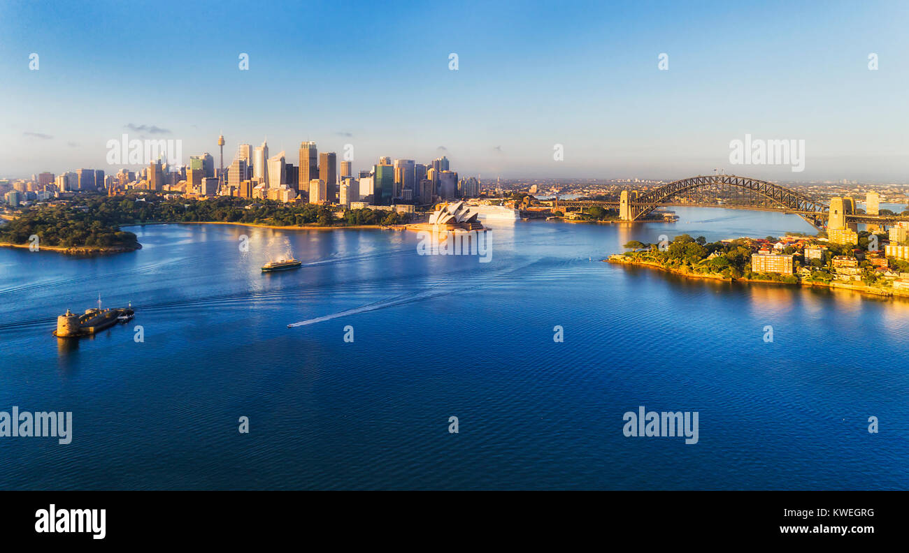 Mid-air view over Sydney harbour shore to city CBD landmarks, Fort Denison and passenger ferry to manly on a sunny summer day. Stock Photo