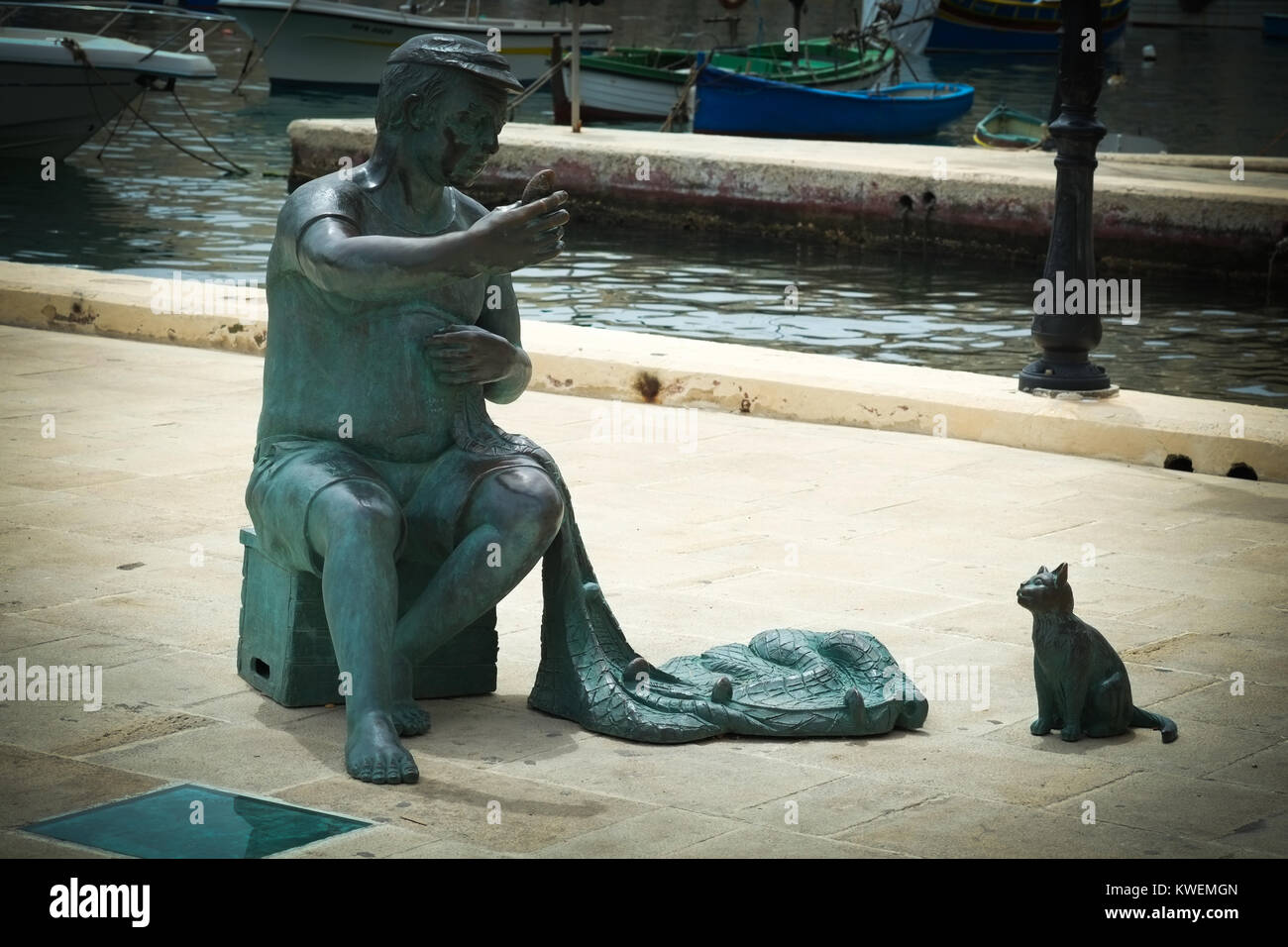 Bronze sculpture of fisherman and cat in Spinola Bay, St Julian's Bay, Malta Stock Photo