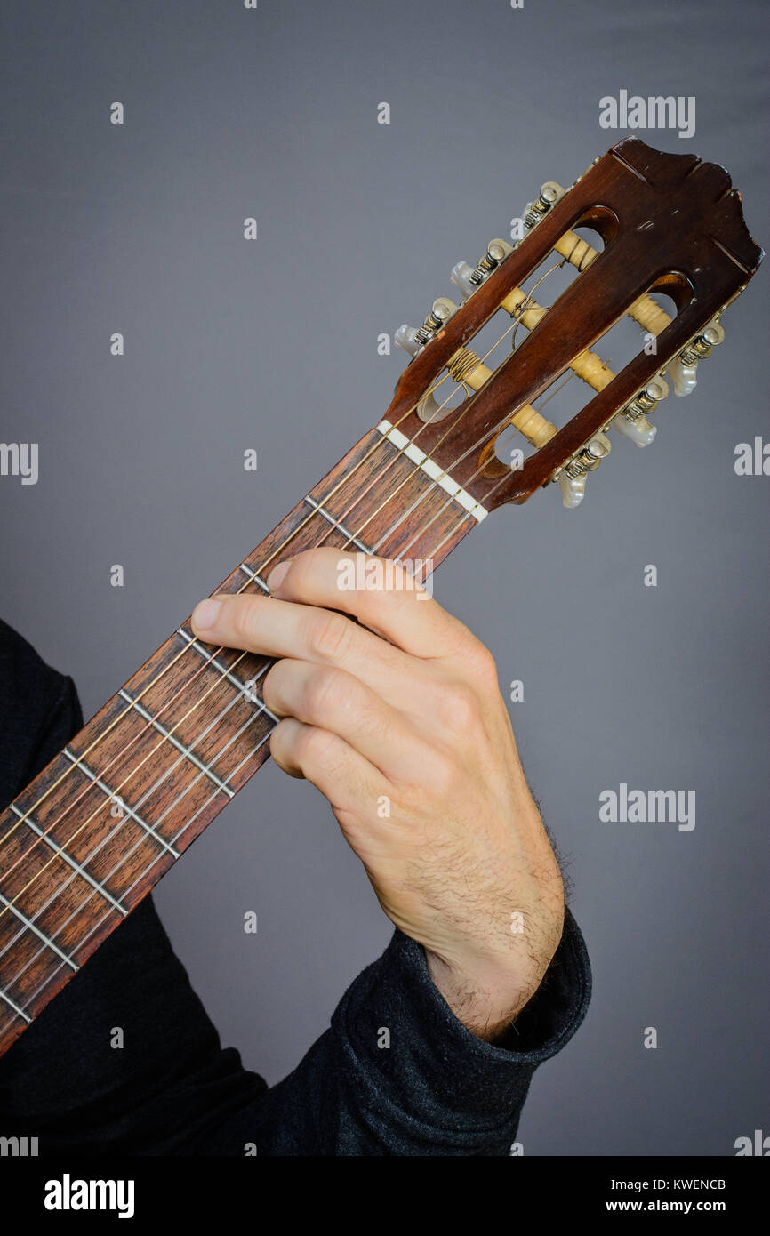 Guitarist playing an G major open chord on classical acoustic guitar