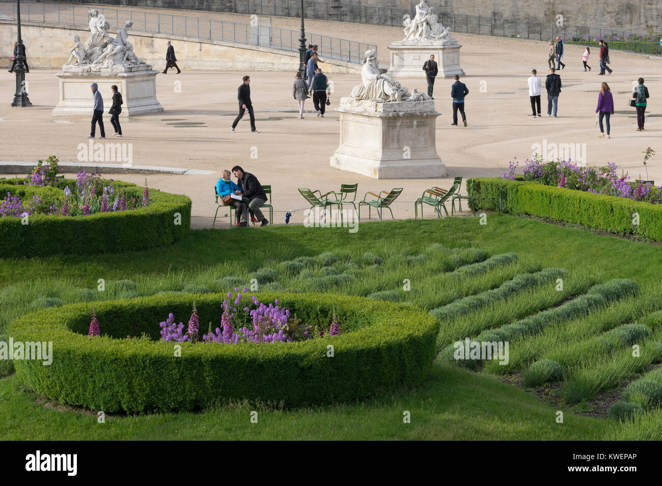 France, Paris, Couple sitting in Truileries Garden with flowers and greenery Stock Photo