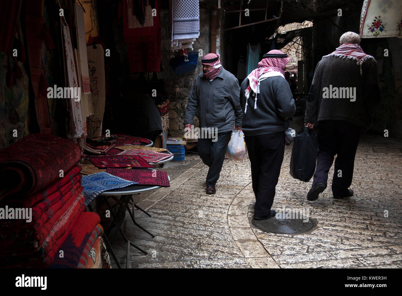 Hebron, Palestine, January 8 2011: Man in kuffiyas head covers walk in an alee  in old town of Hebron Stock Photo