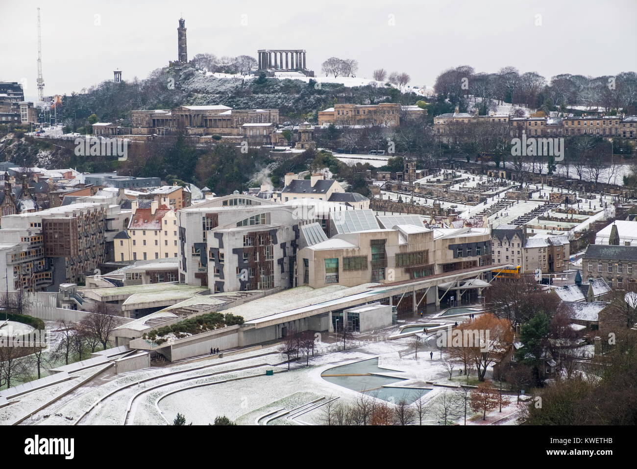 Snow falls on city of Edinburgh in December. Skyline view of city towards the Scottish Parliament Building at Holyrood and Calton Hill. Stock Photo