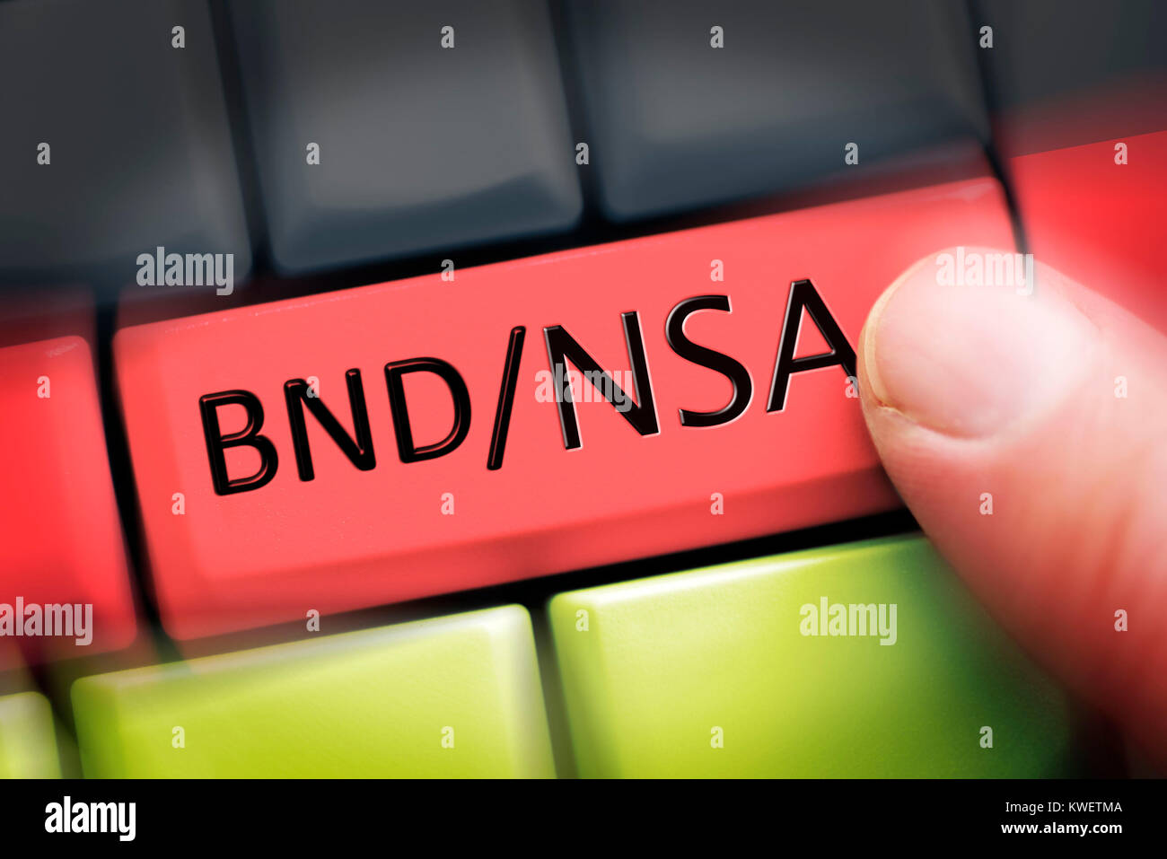 Finger on computer key with NSA and Federal Intelligence Service stroke on German national colours, symbolic photo Federal Intelligence Service scanda Stock Photo