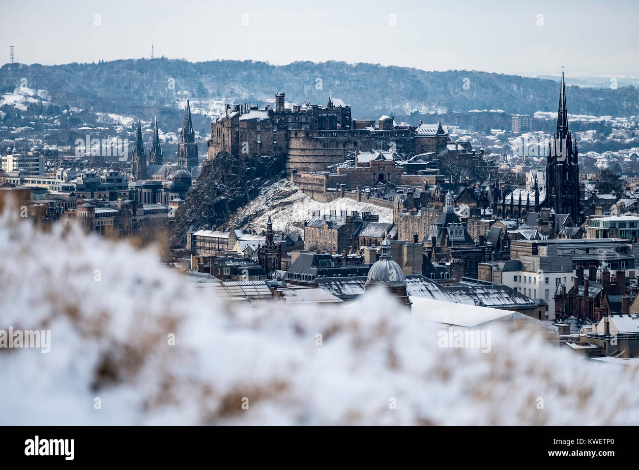 Snow falls on city of Edinburgh in December. Skyline view of city