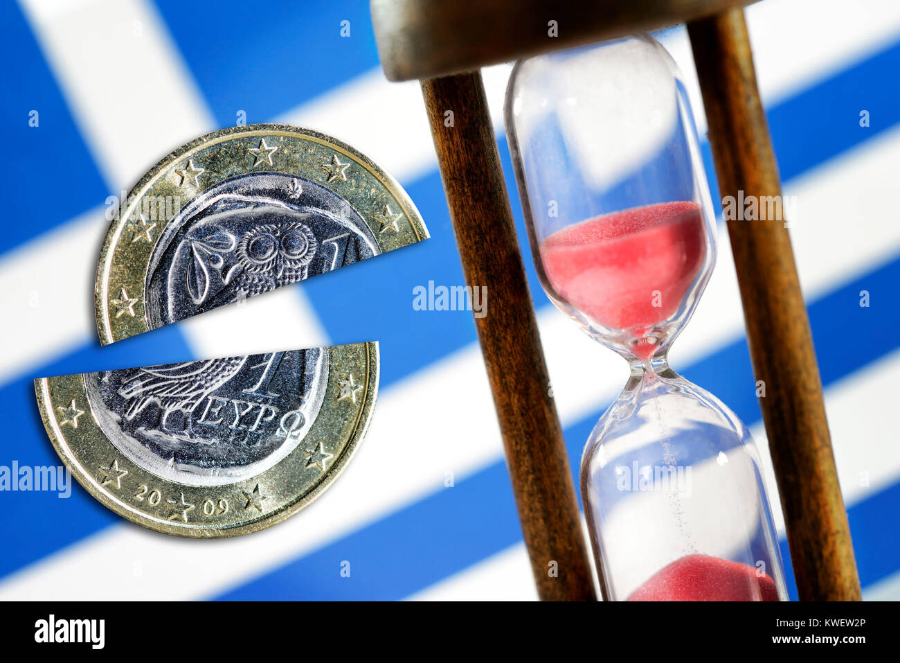 Greek flag, hourglass and intersected eurocoin, symbolic photo debt cut, Griechische Fahne, Sanduhr und durchschnittene Euromünze, Symbolfoto Schulden Stock Photo